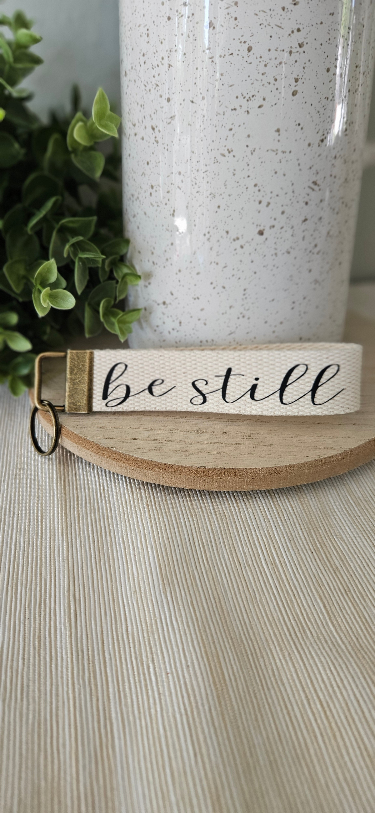 “Faith key fob wristlet with ‘Be Still’ phrase by By Mo Designs” • “Handmade Christian keychain Jesus & Coffee design” • “Cotton webbing faith-inspired key fob with bronze hardware” • “Inspirational wristlet keychain handmade accessory”
